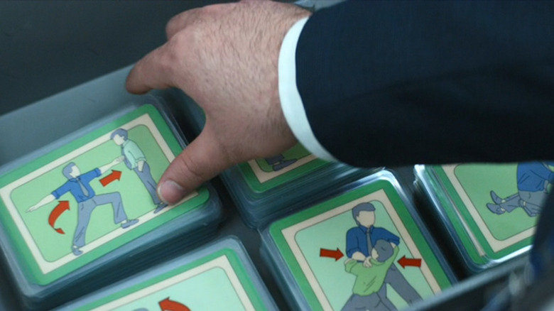 Zach Cherry as Dylan G. stealing a Chikhai Bardo card from Severance season 1