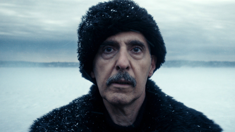 John Turturro como Irving B. vestido com camadas quentes e de pé na neve em um episódio da Severance Season 2