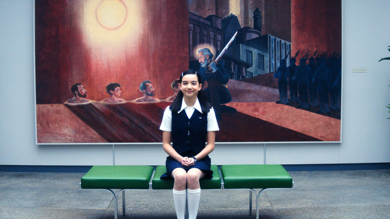 Sarah Bock's Miss Huang sitting on a bench and smiling on Severance