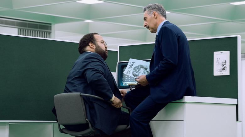 Dylan and Irving holding a Missing poster in the MDR office in Severance season 2