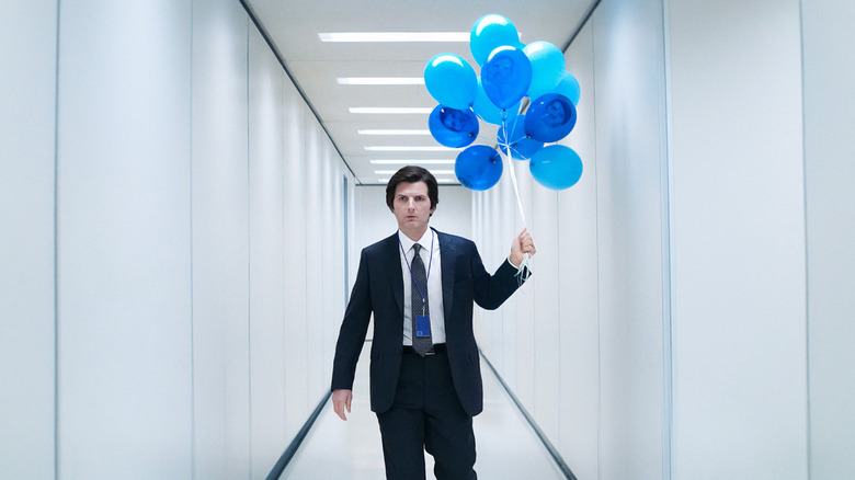 Mark S. walking down the hall at Lumon Industries carrying blue balloons