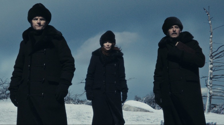 Adam Scott as Mark S., Brit Lower as Helly R., and John Turturro as Irving B. wandering a frozen tundra in Severance season 2