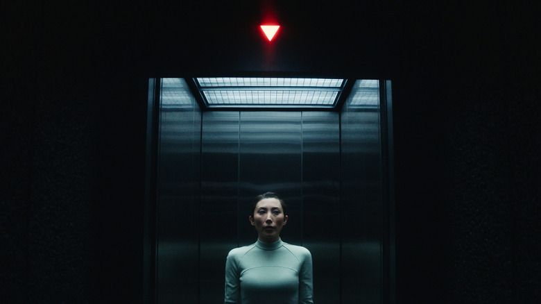 Dichen Lachman's Gemma as her Ms. Casey innie standing in an elevator on Severance