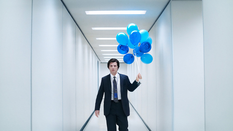 Mark S. walking down the hall at Lumon Industries carrying blue balloons