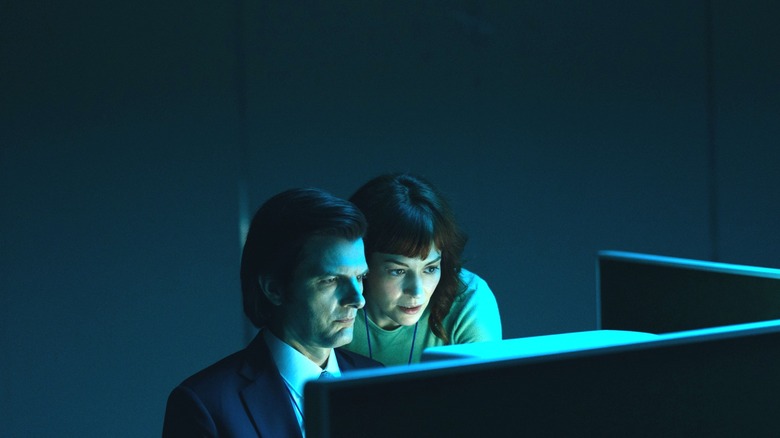 Adam Scott as Mark S. and Britt Lower as Helly R. huddled around their workstation in Severance