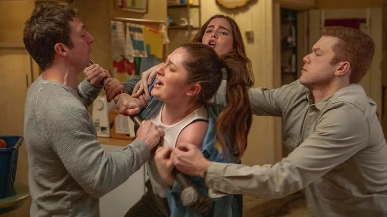 Debbie and Lip fighting while their siblings hold them back in Shameless