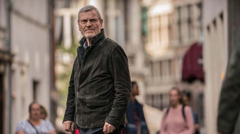 Tchéky Karyo standing in street