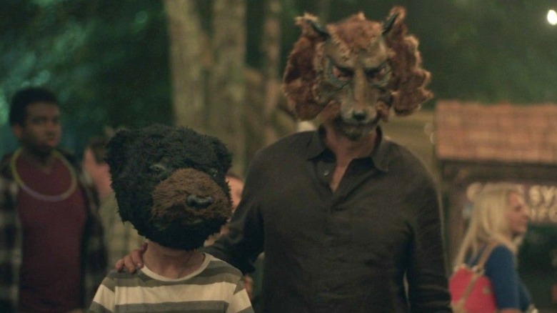 A child and an adult wearing animal masks