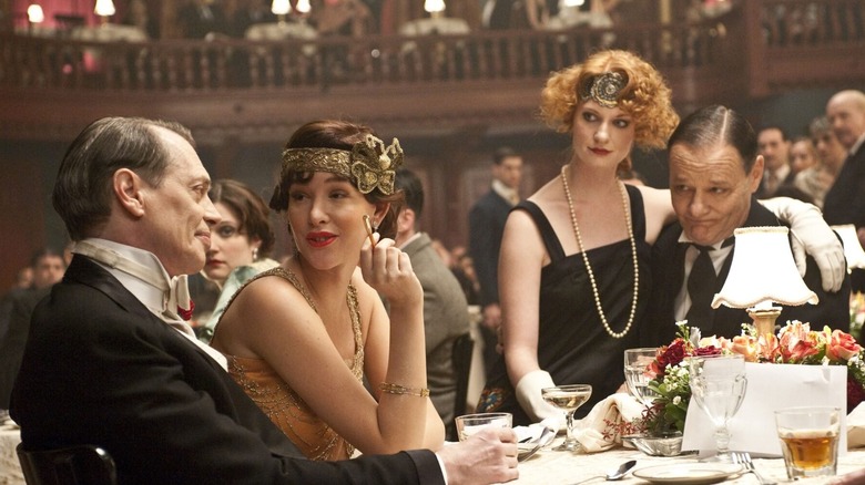 Nucky from Boardwalk Empire sits with flappers at a party