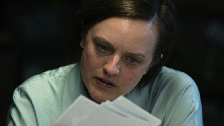 Elisabeth Moss examining paperwork