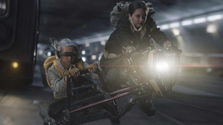 Ryan Kiera Armstrong as Fern riding a space bike through a tunnel while Kyriana Kratter as KB rides sidecar in Skeleton Crew