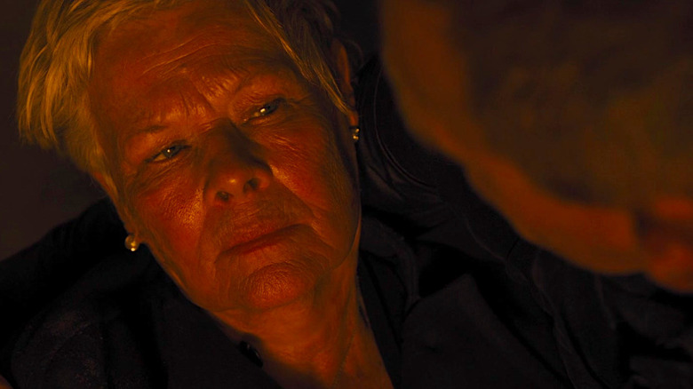 Dame Judi Dench looks up at Daniel Craig as he holds her in his arms in Skyfall