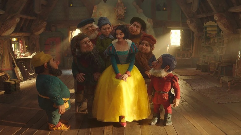 Snow White sitting with the seven dwarfs in Snow White (2025)