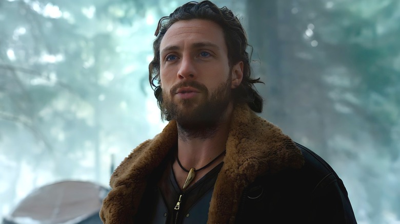 Aaron Taylor-Johnson as Kraven standing in the woods in Kraven the Hunter