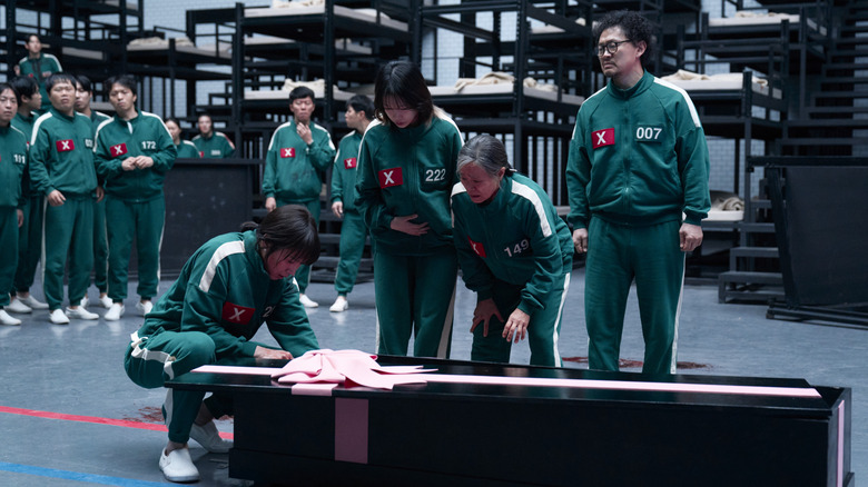 Squid Game, Cho Hyun-ju and the other contestants looking sadly inside a casket