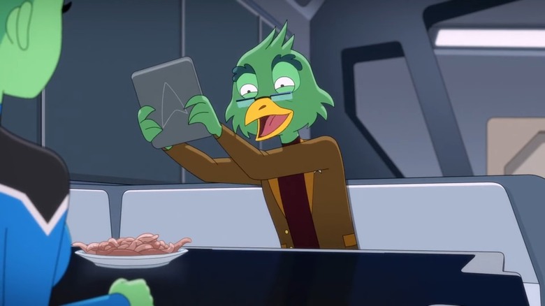 Migleemo looking enthusiastic while showing Tendi a tablet with a Starfleet logo in Star Trek: Lower Decks