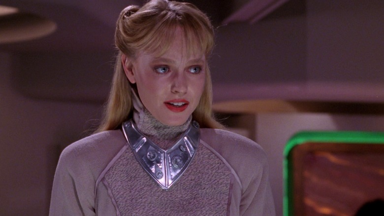 Lisa Wilcox como Yuta, una mujer extraterrestre rubia vestida con un traje plateado, en Star Trek: The Next Generation.