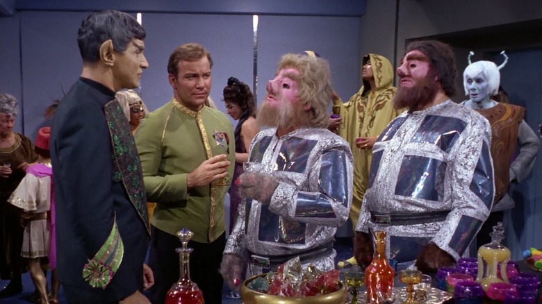 Sarek, Kirk, Gav, another Tellarite, and Thelev, gathered at a banquet on the Enterprise, from an episode of Star Trek