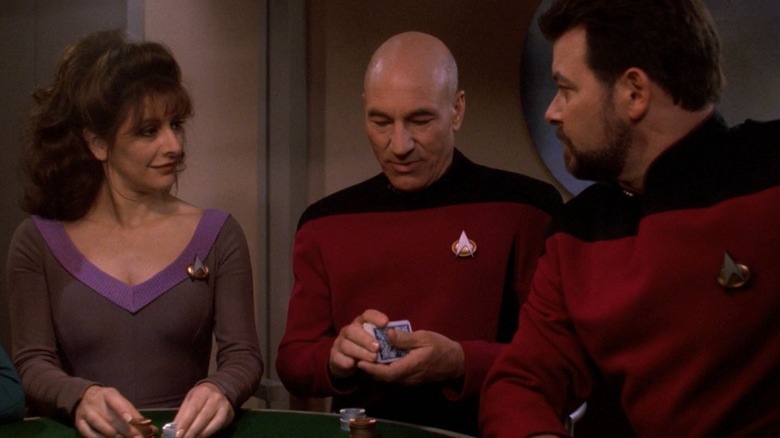 Picard, sitting in between Troi and Riker at a card table, shuffling a deck. From Star Trek: The Next Generation.