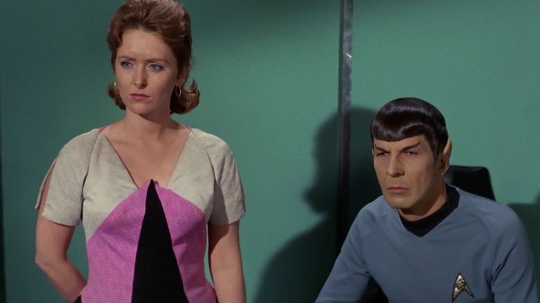 Captain Kirk, in the body of Dr. Janice Lester, standing next to Spock. From Star Trek.