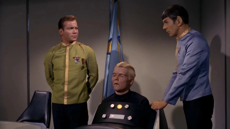 Kirk (William Shatner) watches Spock (Leonard Nimoy) bring in Pike (Sean Kenney) in Star Trek: The Original Series