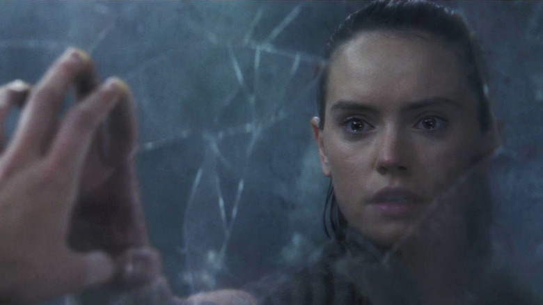 Daisy Ridley as Rey stares at her reflection in Star Wars: Episode VIII - The Last Jedi