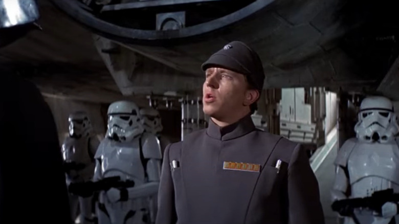Imperial soldier talking to Darth Vader