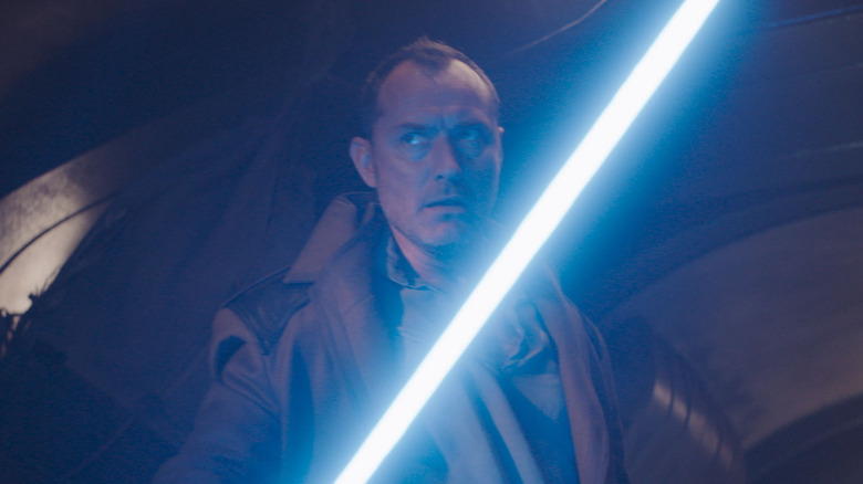 Jude Law as Jod Na Nawood holding his lightsaber in Star Wars: Skeleton Crew