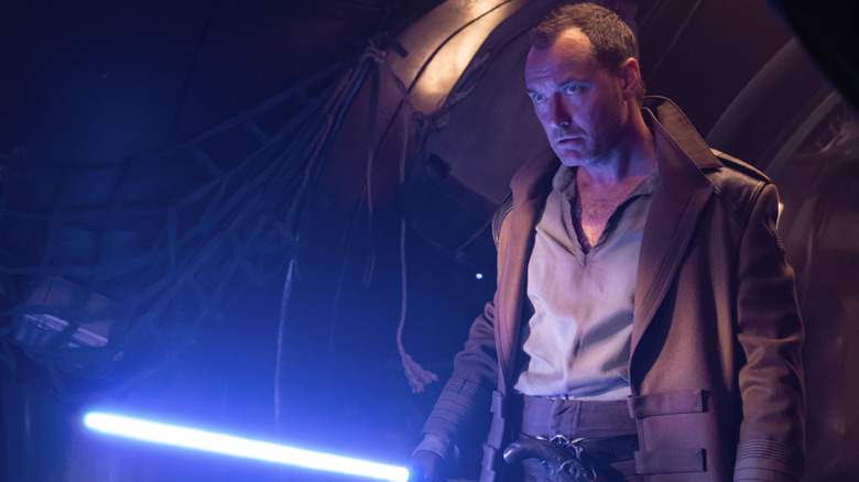 Jude Law como Jod Na Nawood segurando seu sabre de luz em Star Wars: Skeleton Crew