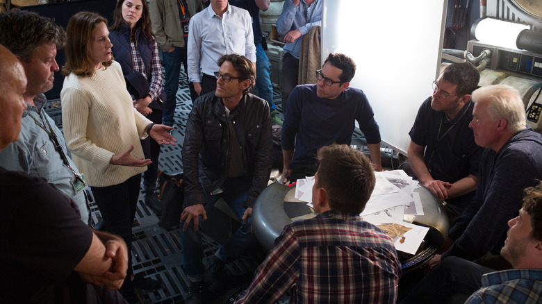 Kathleen Kennedy (left, in white) talks to J.J. Abrams (at table, center) and team on the Millennium Falcon set.