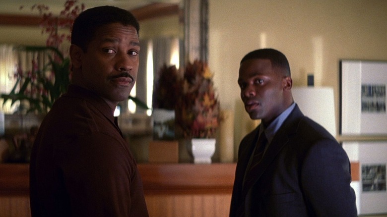 Lt. Cmdr. Dr. Jerome Davenport looking over his shoulder, Antwone Fisher looking at the same thing. Both are in a modest suburban home.