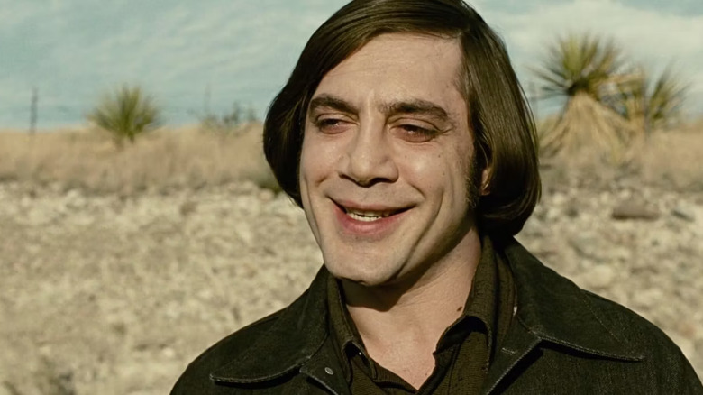 Anton Chigurh bob haircut smiling in desert No Country for Old Men