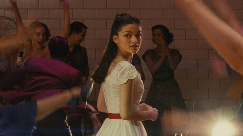 a woman in a white dress looking over her shoulder