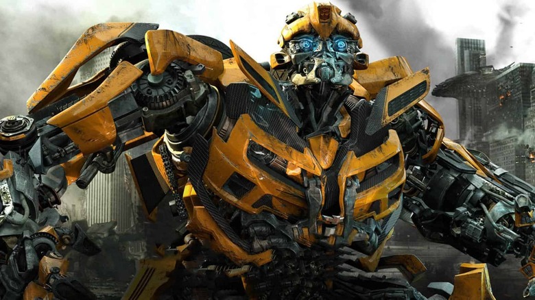 a yellow and black transformer with bright blue eyes