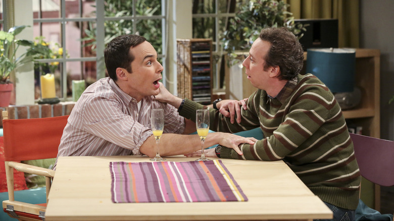 Sheldon and Stuart drinking mimosas and grabbing each other's arms on The Big Bang Theory