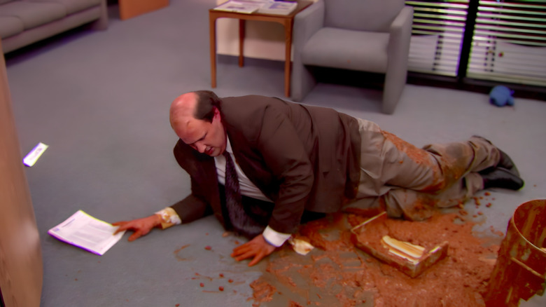 Kevin Malone deitado em uma piscina de pimenta no escritório