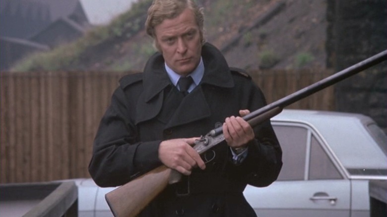 Michael Caine mengacungkan senapan sebagai Jack Carter Dapatkan Carter