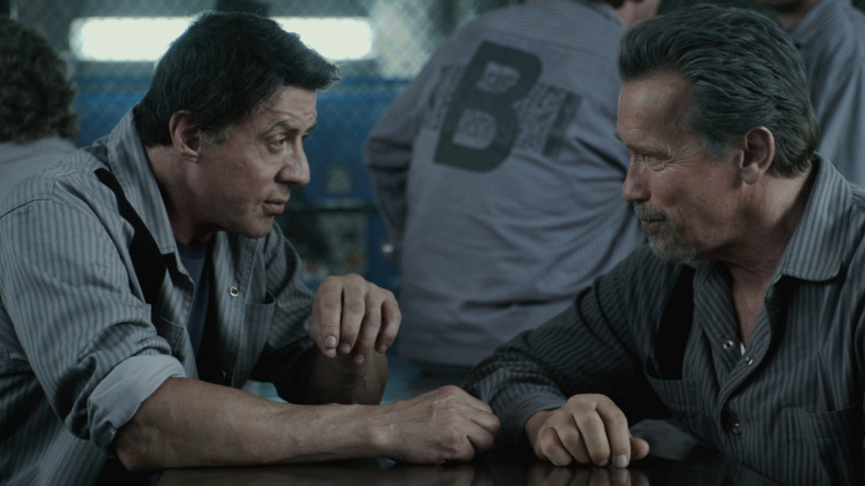 Sylvester Stallone's Ray Breslin sits across from Arnold Schwarzenegger's Emil Rottmayer at a prison table in Escape Plan