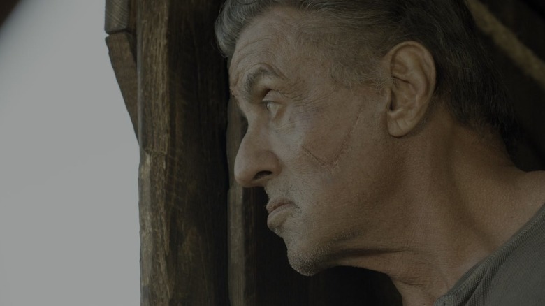 Sylvester Stallone's John Rambo looks out of a window in Rambo: Last Blood