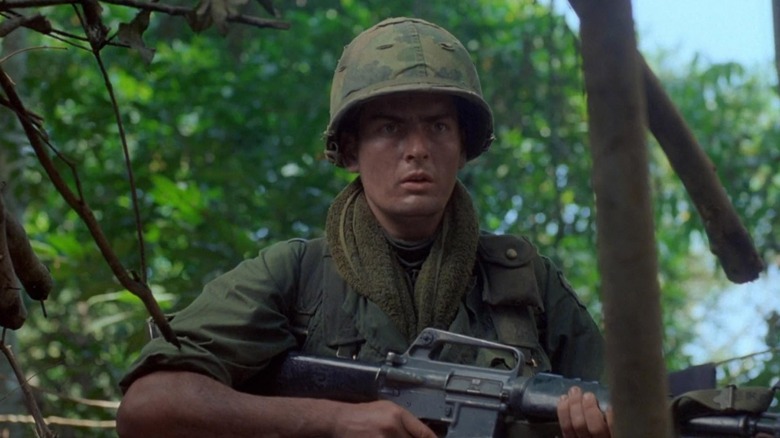 Chris Talyor, holding a machine gun, in Platoon