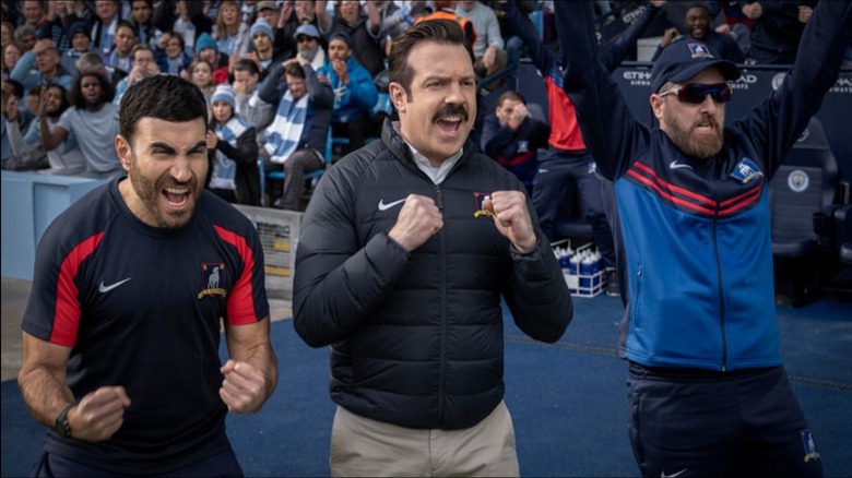 Brett Goldstein's Roy Kent, Jason Sudeikis' Ted Lasso, and Brendan Hunt's Coach Beard celebrating on Ted Lasso