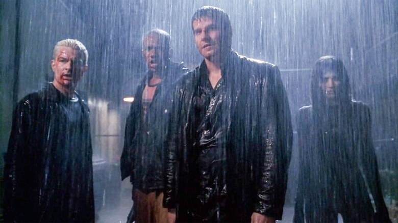 The cast of Angel stands in the rain