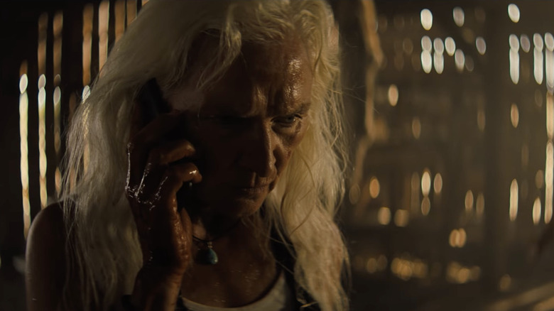 a woman with white hair on the phone in shadow