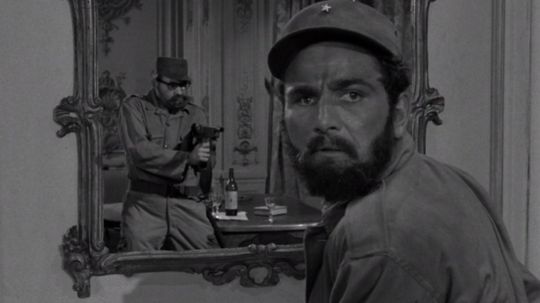 A man points a gun at Ramos Clemente (Peter Falk) in The Mirror