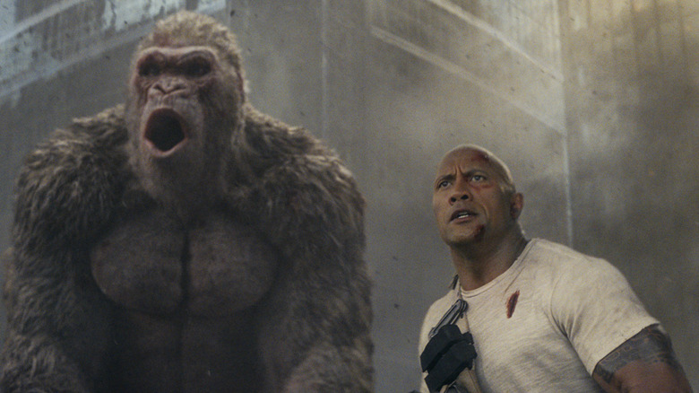 Giant ape George with Davis Okoye, played by Dwayne Johnson, surveying the Rampage damage