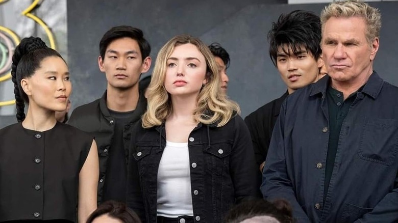 Peyton List's Tory Nichols standing with Cobra Kai dojo members on Cobra Kai