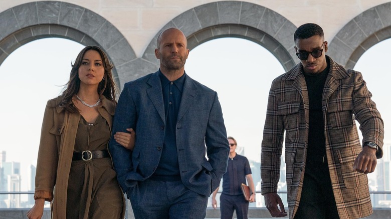 Aubrey Plaza, Jason Statham, and Bugzy Malone walking cool