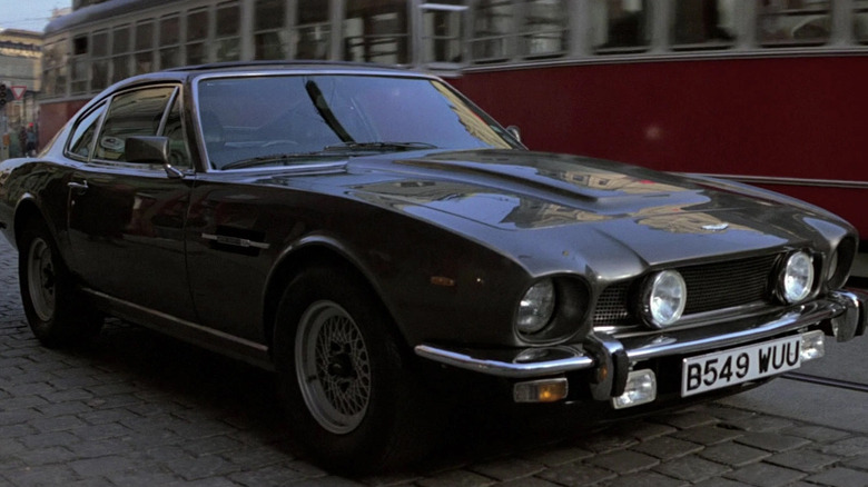 James Bond's Aston Martin V8 sits in front of a trolly car in in The Living Daylights