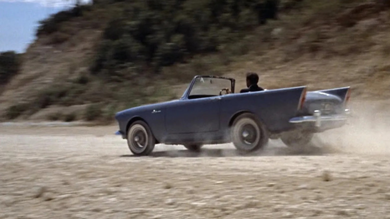 James Bond (Sean Connery) drives a Sunbeam Alpine on a dirt road in Dr. No