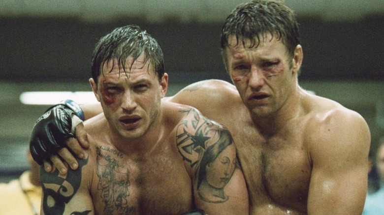 Tom Hardy and Joel Edgerton as Tom and Bendan Conlon holding each other in Warrior